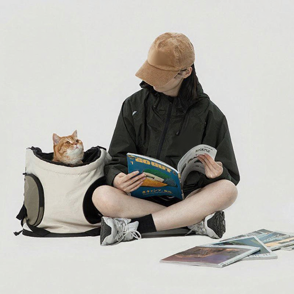 Catvera Front Cat Carrier Backpack - Image 7|||PROMPT|||Cleaned image. Original analysis: Found 2 brand logos/names: 1) circular logo patch on the tan/beige cap, 2) circular emblem/logo on the black jacket