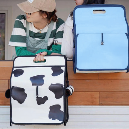 Catvera Milk Carton Cat Carrier - Image 11|||PROMPT|||Cleaned image. Original analysis: Found 3 brand names printed directly on the products: 'milk' with 'designed by purpy' on the cow-print bag (left), 'milk' on the blue bag (right), and a milk carton icon with '2500 ml' capacity marking on the blue bag
